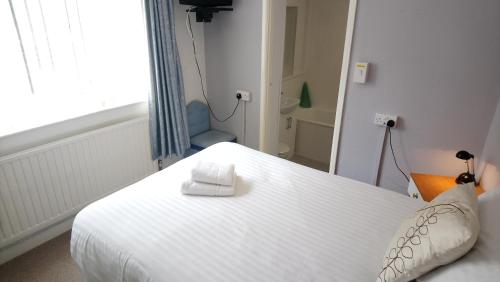 a white bed in a room with a window at The Great Western B&B in Paignton