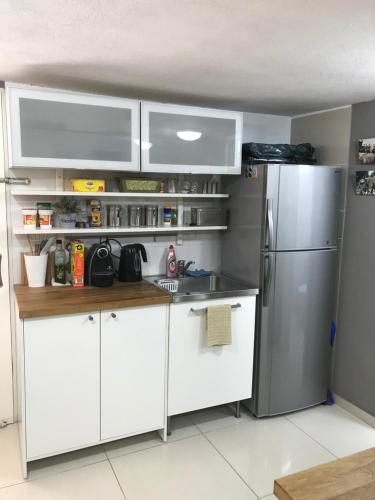 a kitchen with white cabinets and a stainless steel refrigerator at Apartment Caesarea 38 in Caesarea