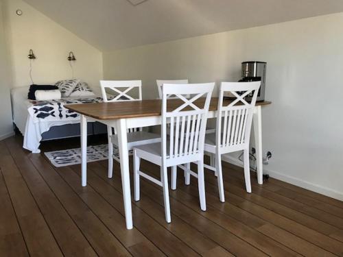 a white dining room table with white chairs and a bed at Björkö SeaLodge in Björkö