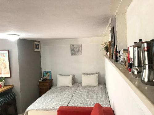 a small bedroom with a bed and a red couch at Apartment Caesarea 38 in Caesarea