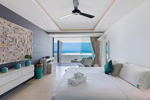 Un dormitorio con una cama con ventilador de techo. en Villa Atlantis 6 - Deluxe 2BDR, Sea View, Private Pool, en Chaweng Noi Beach