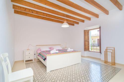 biała sypialnia z łóżkiem i krzesłem w obiekcie Casa Canals w mieście Mancor del Valle