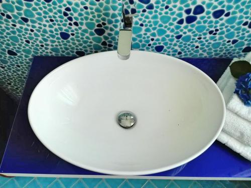 a white sink sitting on top of a blue counter at B&B Villa Claudia in Lavena Ponte Tresa