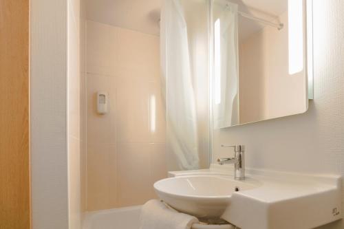 een witte badkamer met een wastafel en een douche bij B&B HOTEL Boulogne Sur Mer in Saint-Martin-Boulogne