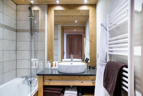 y baño con lavabo, bañera y bañera. en Résidence - Les Grandes Alpes en La Clusaz