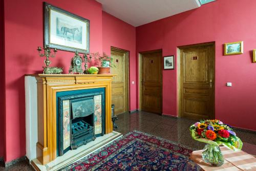 a living room with a fireplace and pink walls at Wellnesshotel Legde in Legde