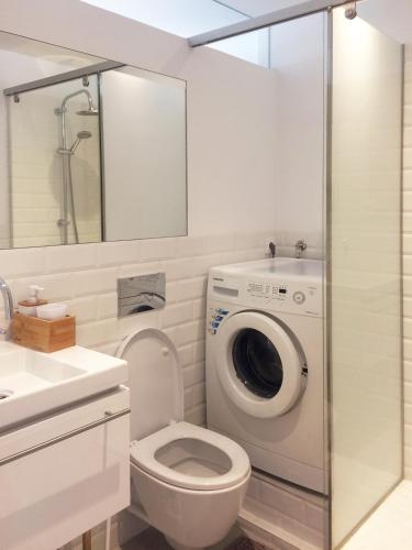 a bathroom with a toilet and a washing machine at Studio 177 in Matosinhos