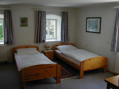 two beds in a bedroom with two windows at Ferienhaus-Loidl in Bad Ischl