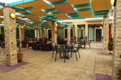 an outdoor patio with chairs and tables at Aeolian Gaea Hotel in Skala Kallonis