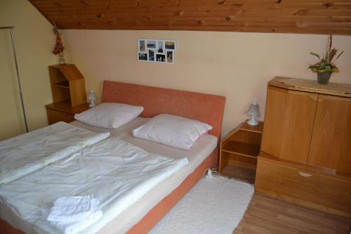 a small bedroom with a bed with two pillows at Penzion Alfa Tatry in Stará Lesná