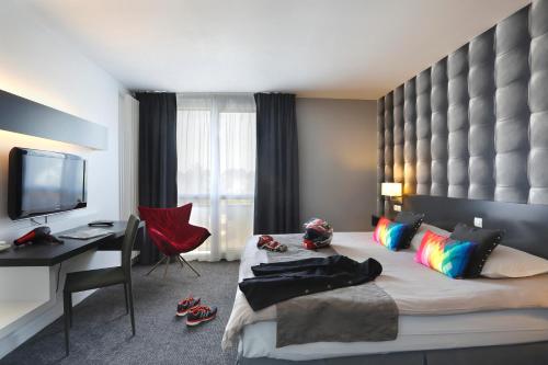 a hotel room with a bed and a desk and a computer at Altos Hotel & Spa in Avranches