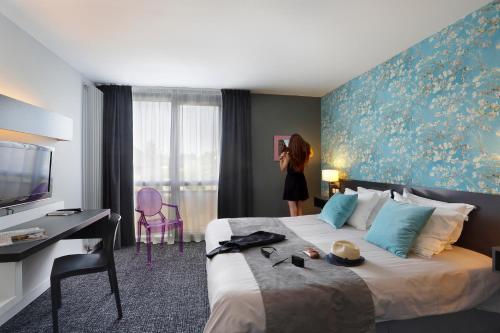 a woman taking a picture of a hotel room at Altos Hotel & Spa in Avranches