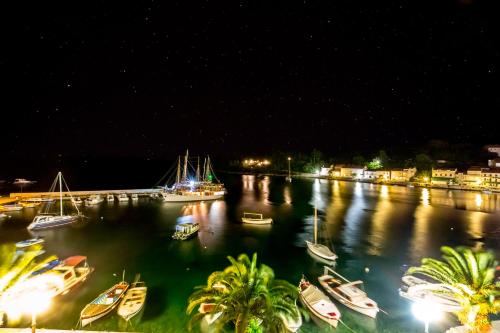 a group of boats docked in a harbor at night at Divna Apartments and Rooms in Račišće