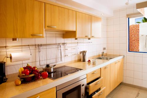 モロ・デル・ハブレにあるSalinasのキッチン(木製キャビネット付)、カウンターにフルーツを用意しています。