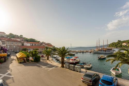 a marina with boats in the water and cars parked at Divna Apartments and Rooms in Račišće