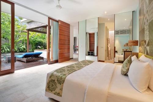 a bedroom with a large bed and a patio at The Elysian Boutique Villa Hotel in Seminyak