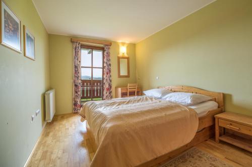 sypialnia z dużym łóżkiem i oknem w obiekcie Apartmajsko naselje Ribniško Pohorje w mieście Ribnica na Pohorju