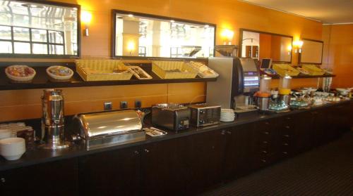 ブーグネにあるHôtel Oceania Nantes Aéroportのレストランのビュッフェの列に食べ物が並んでいる