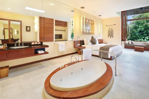 a bathroom with a large tub in a room at The Elysian Boutique Villa Hotel in Seminyak
