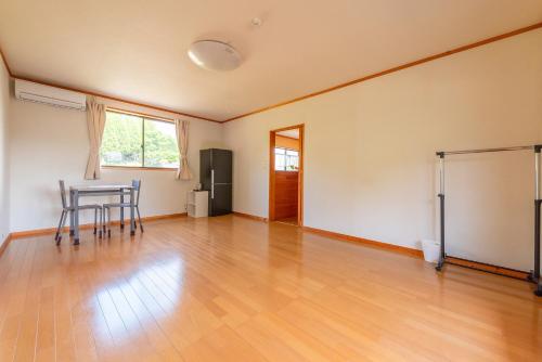 an empty living room with a table and chairs at Share Creative&Bed adonoan in Takeo