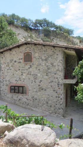 a stone building with two windows on the side of it at Fattoria Armonia in Stilo