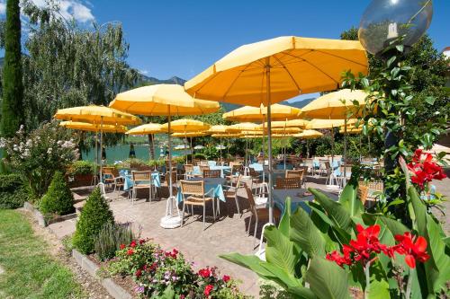a group of tables and chairs with yellow umbrellas at PENSION KLUGHAMMER in Caldaro