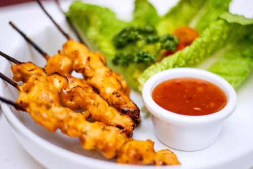 a plate of food with shrimp and a bowl of sauce at Ben Nevis Hotel & Leisure Club in Fort William