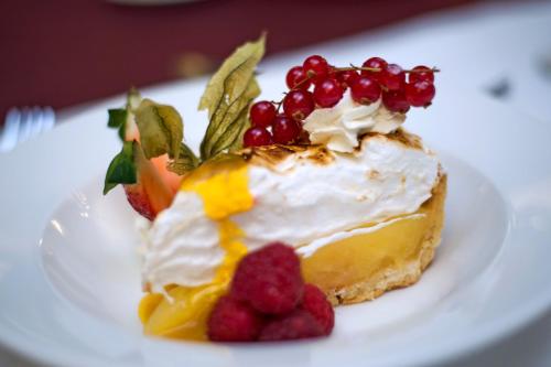a piece of cake with fruit on a white plate at Ben Nevis Hotel & Leisure Club in Fort William