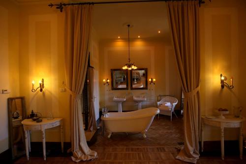 a bathroom with a bath tub and two tables at Zabola Estate - Transylvania in Zăbala