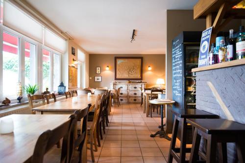 a restaurant with tables and chairs in a room at B&B Le Vieux Marronnier in Foy-Notre-Dame