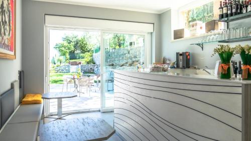 a kitchen with a counter with a table and a window at Hotel Casa Marinella in Malcesine