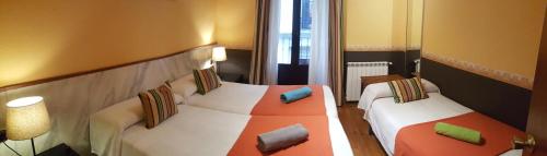 pokój hotelowy z 2 łóżkami i poduszkami w obiekcie Pension Aries w mieście San Sebastián