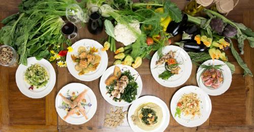 a table topped with plates of food and vegetables at TENUTAYALA - Residenza Agrituristica in Parabita