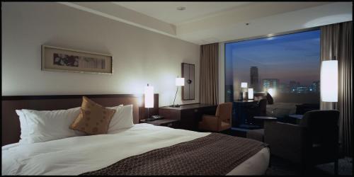a hotel room with a bed and a large window at Hotel New Otani Tokyo The Main in Tokyo