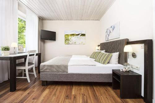 Hotel Hinrichs في كاروليننسيل: غرفة نوم بسرير وطاولة ومكتب