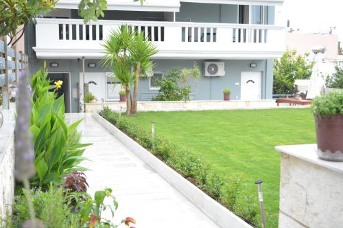 a house with a green lawn in front of it at Thegaia Studios in Rethymno Town