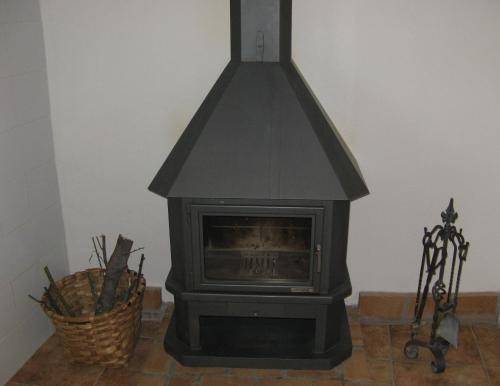 a black stove in a room with a basket at Mas de Bruquet in Llimiana