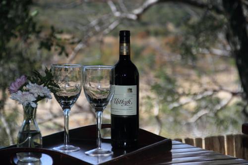 a bottle of wine sitting on a table with two glasses at Tantebane Game Ranch in Tantebane