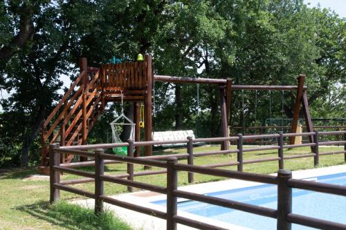 a wooden playground with a slide in a park at BorgoPratole CountryHouse in Cingoli