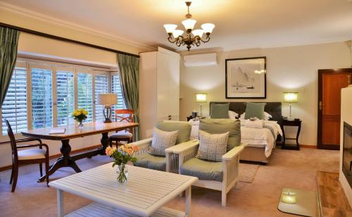 ein Wohnzimmer mit einem Bett und einem Tisch in der Unterkunft Bellgrove Guest House Sandton in Johannesburg