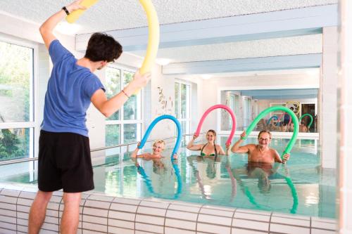 a group of people playing in a swimming pool at AktiVital Hotel in Bad Griesbach