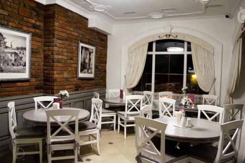 a restaurant with tables and chairs and a window at Nota Bene Hotel & Restaurant in Lviv