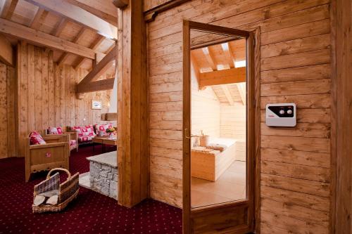 a wooden room with a mirror and a sitting room at Le Refuge in La Rosière