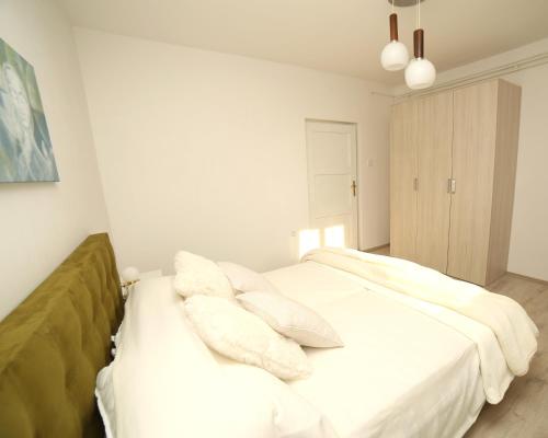 a bedroom with a bed with white sheets and pillows at Garden in Pula