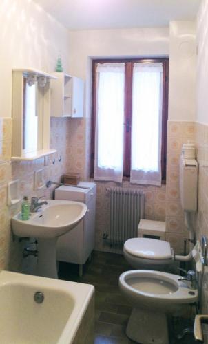a bathroom with a toilet and a sink at ELDA's Home - Ideale per famiglie in Pinzolo