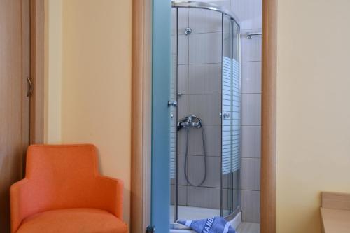 łazienka z prysznicem z pomarańczowym krzesłem w obiekcie Hotel Manthos Blue w mieście Agios Ioannis Pelio