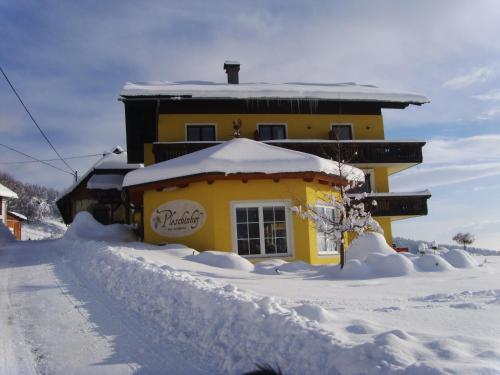 a house covered in snow in front at Pleschinhof in Velden am Wörthersee