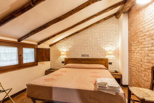 a bedroom with a bed and a brick wall at Hotel Santa Maria in Santa Maria Navarrese