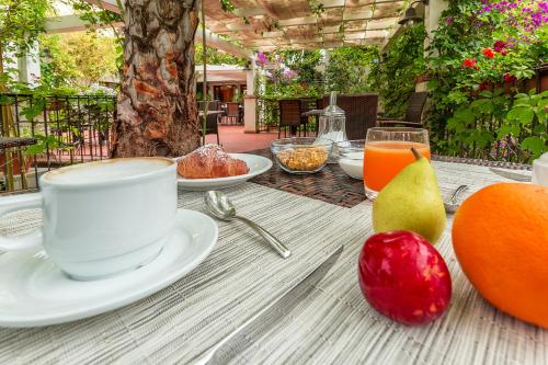 a table with a cup of coffee and fruit on it at Hotel Santa Maria in Santa Maria Navarrese