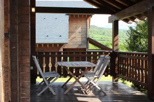 two chairs and a table on the porch of a cabin at Piedrafita Mountain in Piedrafita de Jaca